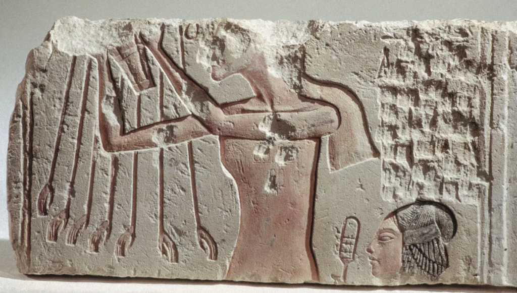 Defaced image of Akhenaten with one of his daughters and extended rays of Aten.
